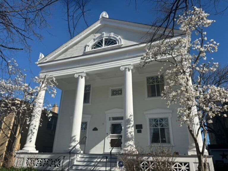 Front porch of a house with large pillars.