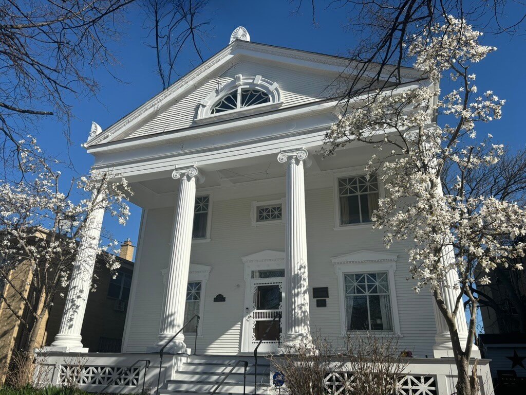 Front porch of a house with large pillars.